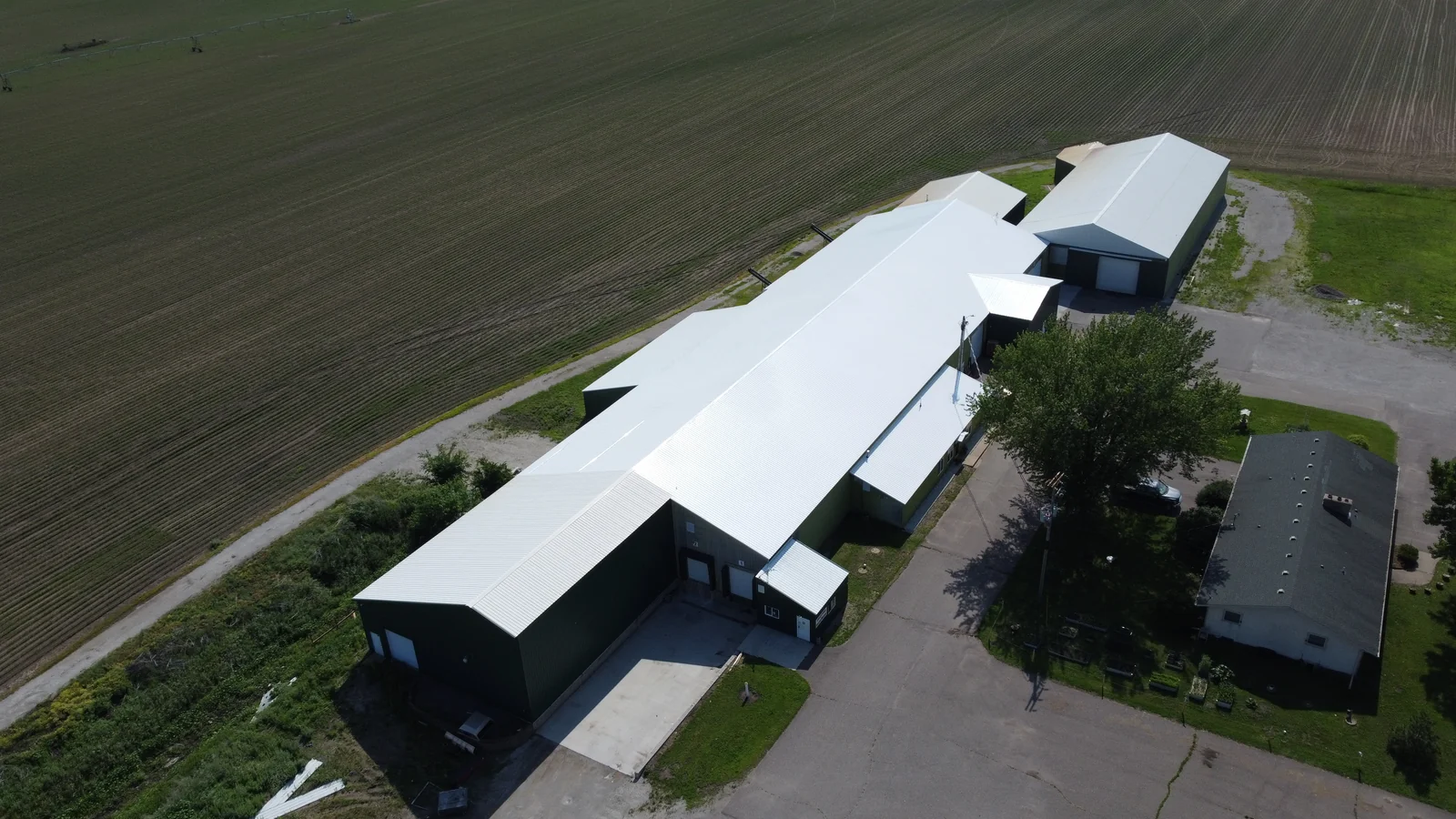 Dark-walled barn end capped with a clean silver metal roof