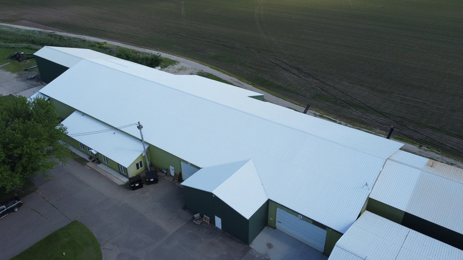 Metal-roofed barn with an attached lean-to and a curving gravel driveway