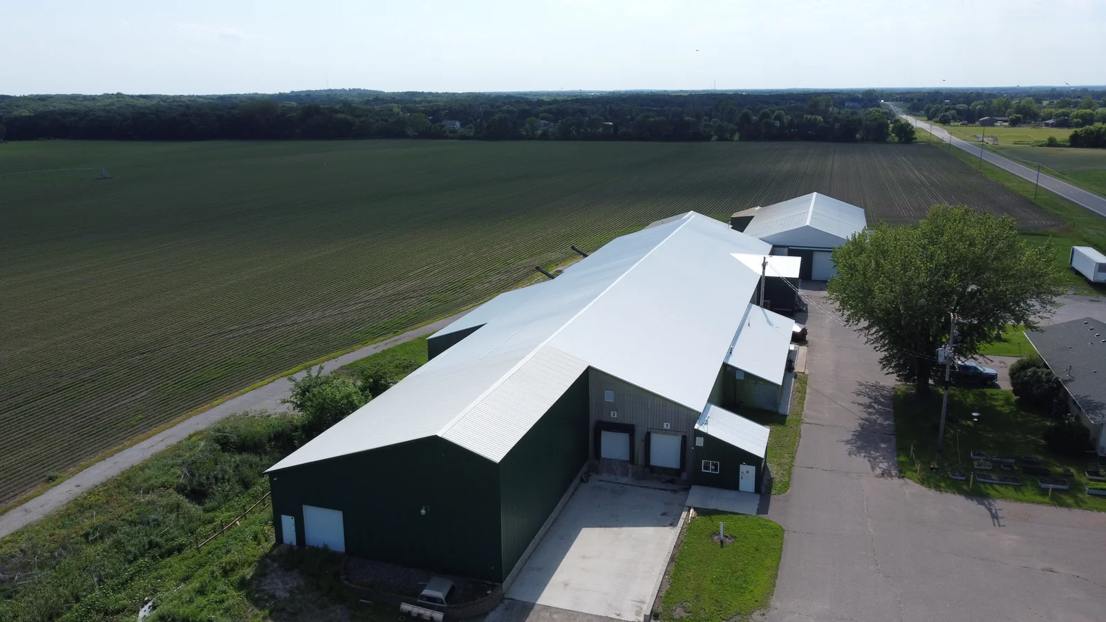 The finished metal roof seen from the gravel yard at the building's corner