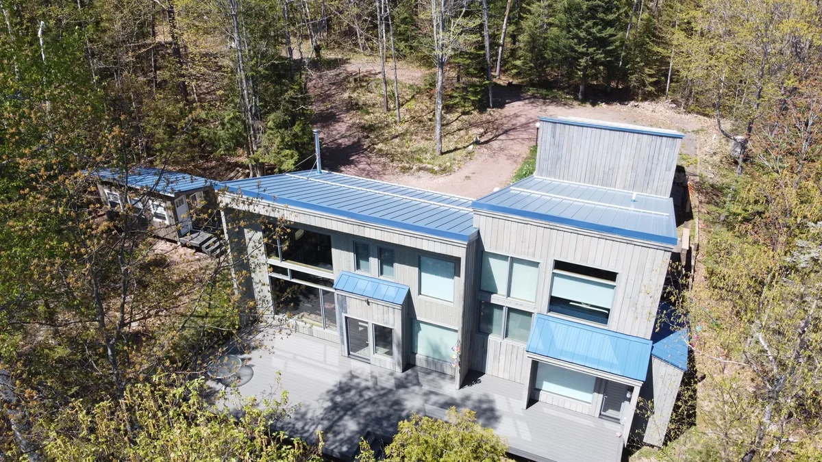 Overhead look at the crisp blue standing seam panels and the home's lower roof sections