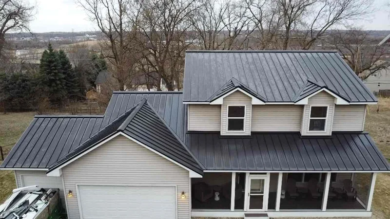 Aerial view of a two-story home with a dark charcoal metal roof and front porch in Cottage Grove, MN