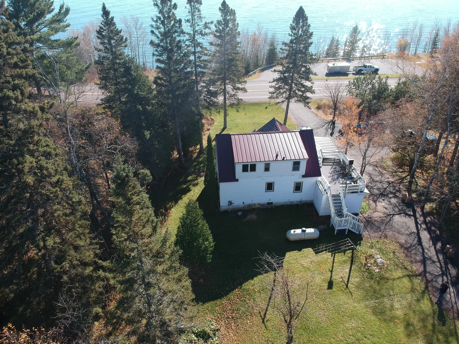The red metal roof nestled among tall pines on the wooded lot.