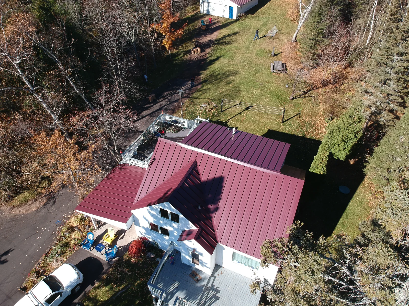 Close aerial of the red metal panels meeting white trim along the eaves.