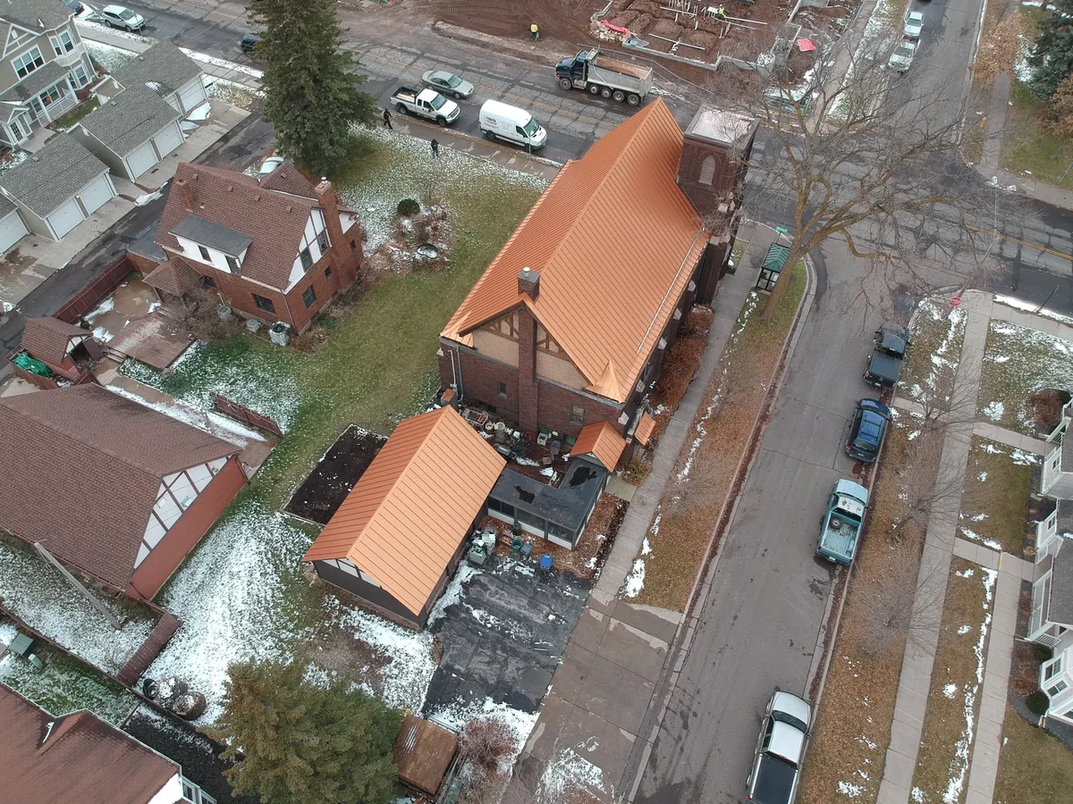 Drone perspective of the warm copper metal roof stretching across the historic downtown structure.