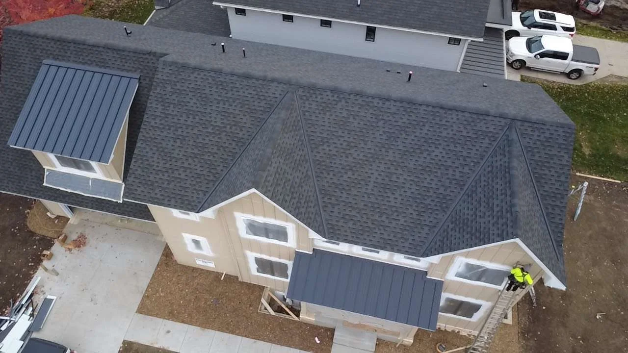 Aerial view of a large home in Edina, MN where charcoal standing seam metal accents pair with gray asphalt shingles
