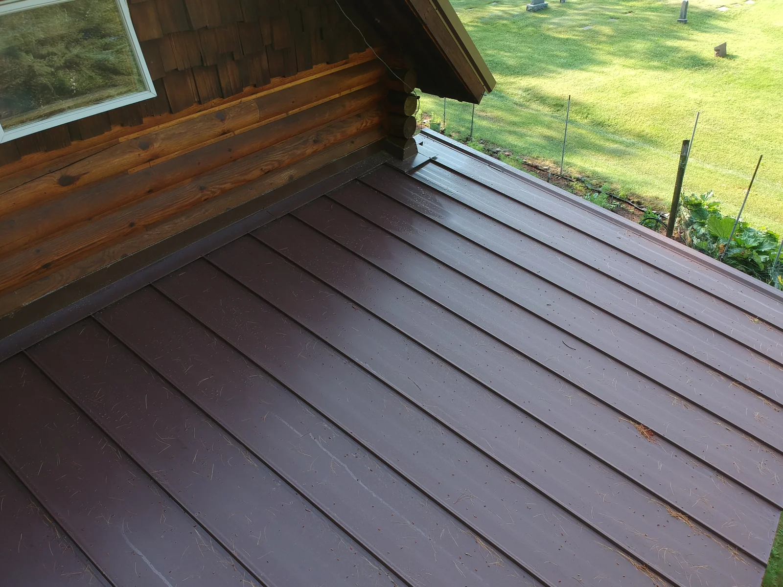 Close look at the ridge and brown panels of the exposed-fastener metal roof
