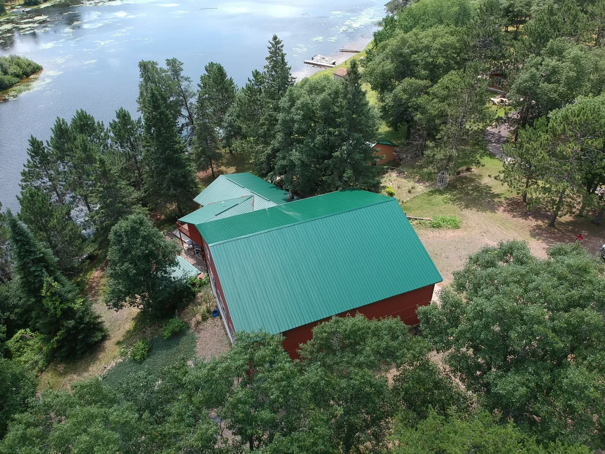 The green metal roof with the river and shoreline visible in the background