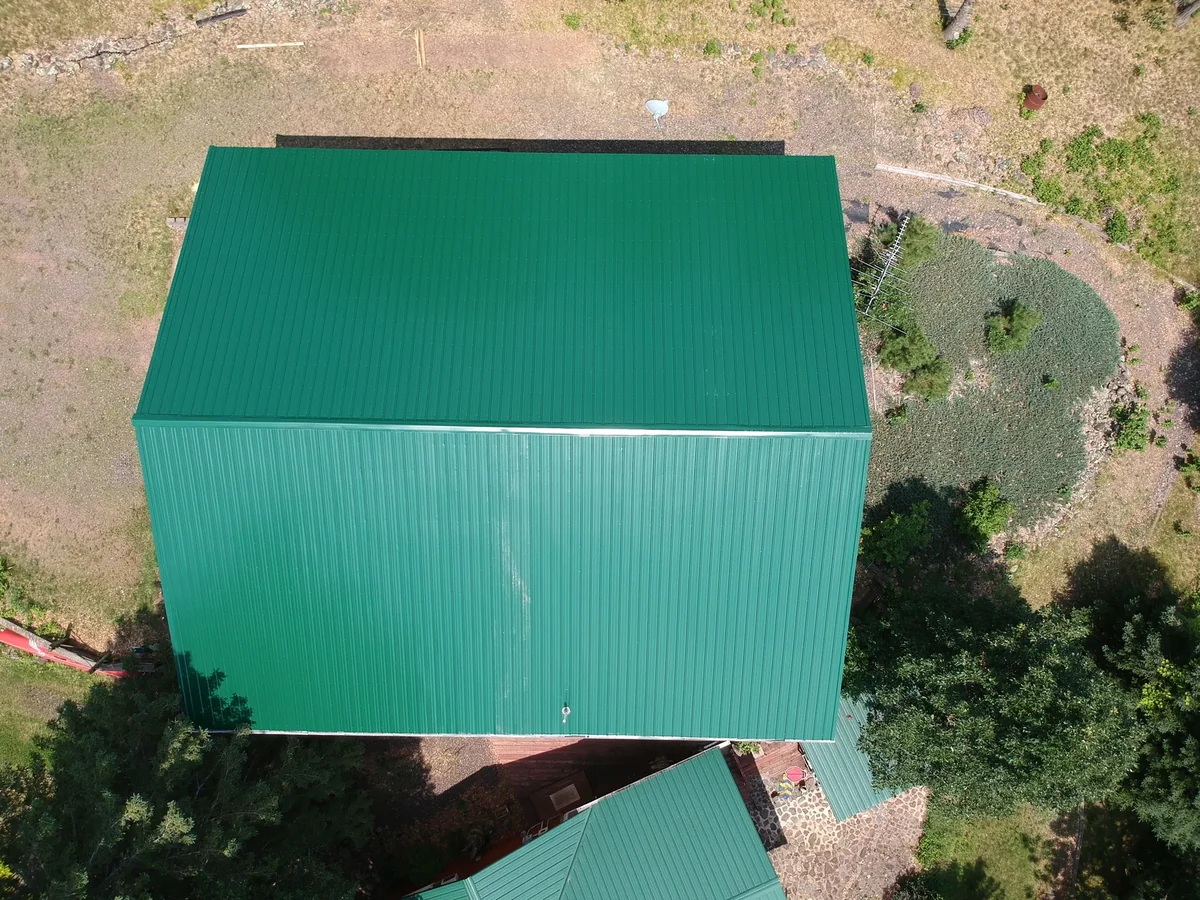 Top-down detail of the bright green standing seam panels and ridge