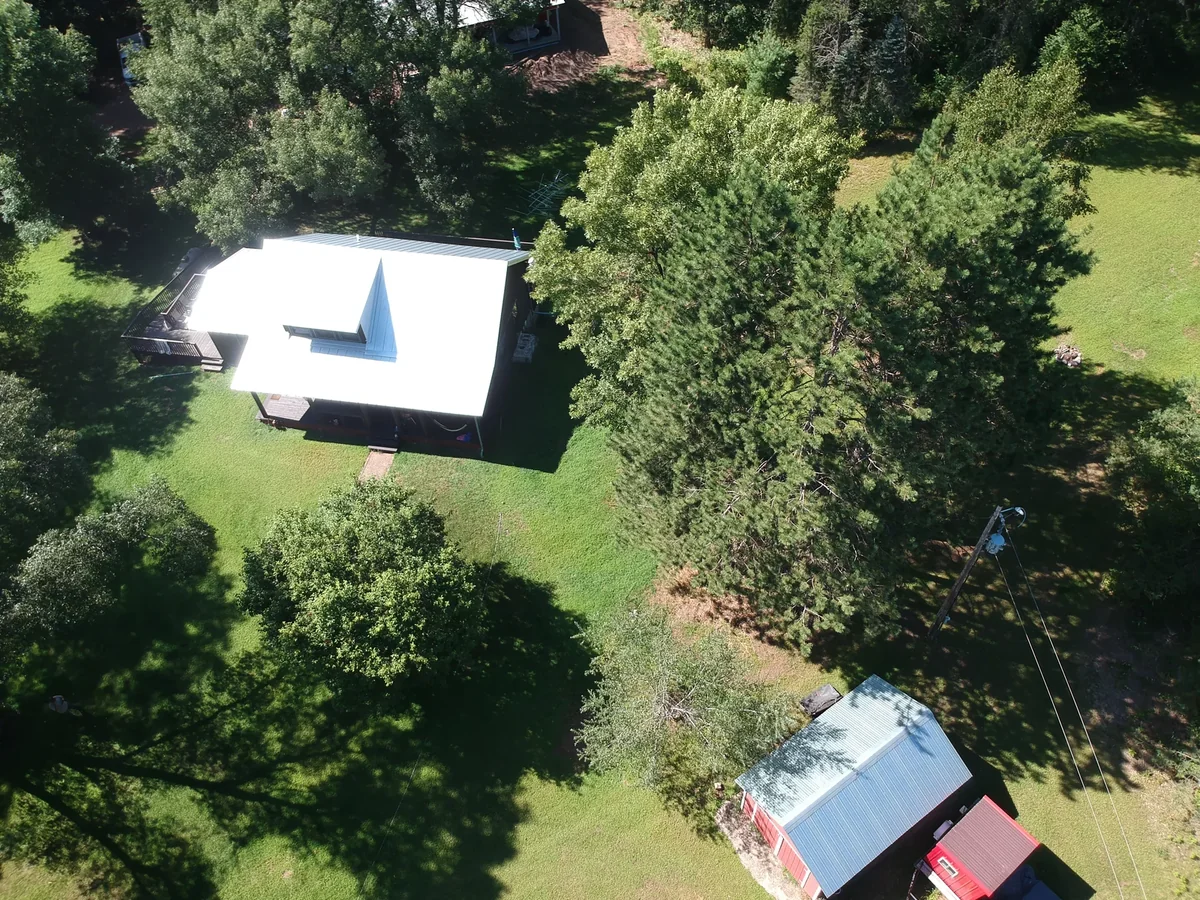 High overhead shot of the metal roof with a small matching outbuilding nearby.