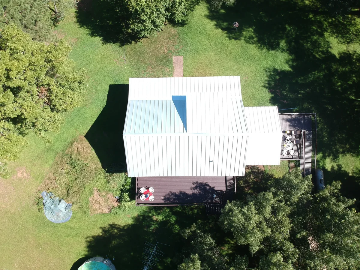 Straight-down view of the metal panels and ridges across the full roof.