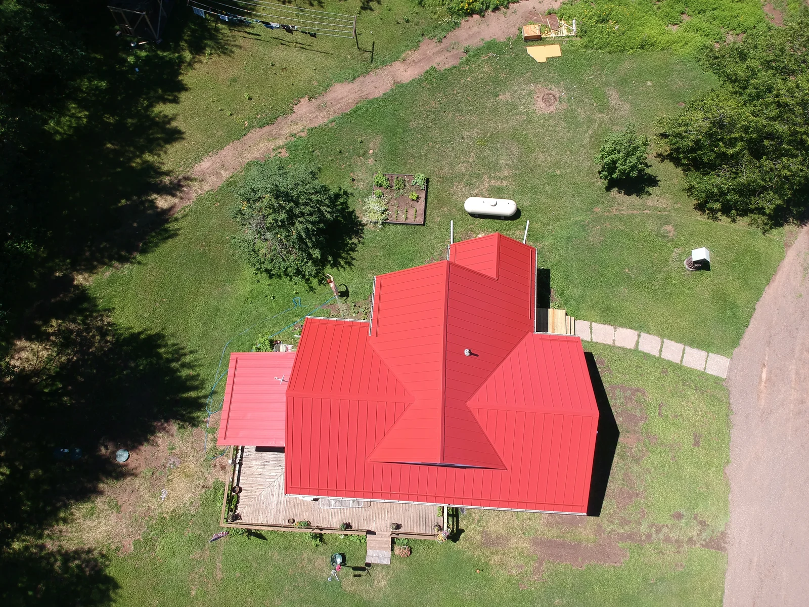 Overhead view of the vivid red metal roof and its multiple gables