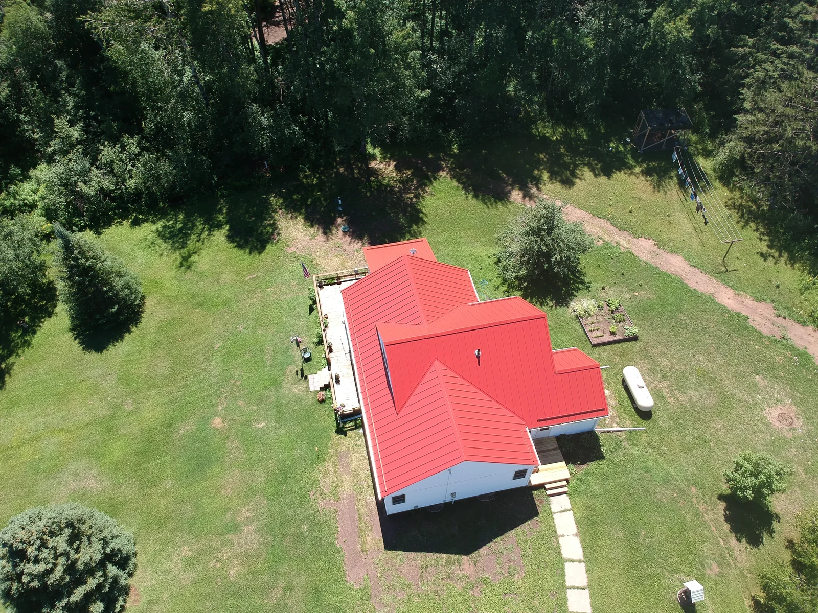 Top-down view of the rectangular red metal roof and surrounding gravel apron