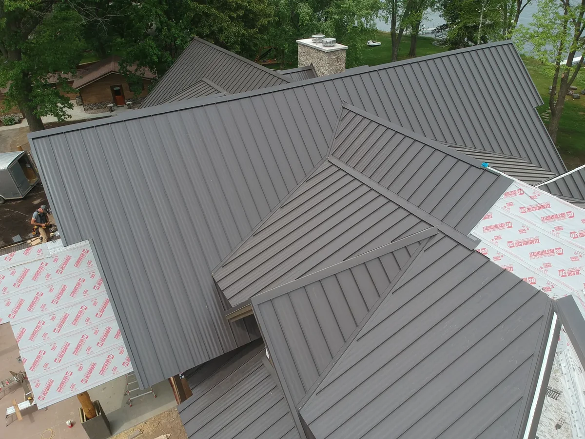 Lower-angle look at the dark standing seam roof sections meeting at the ridges.