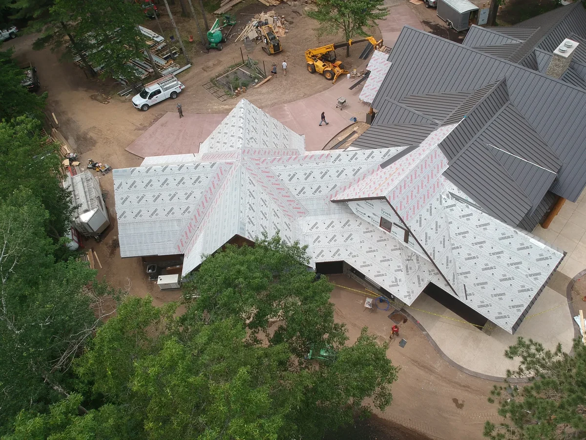Top-down view capturing the freshly seamed panels next to areas still in underlayment.