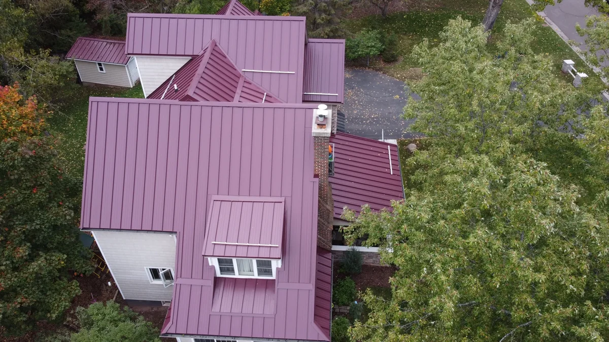 Overhead view of the multi-gable red metal roof and its many ridges and valleys