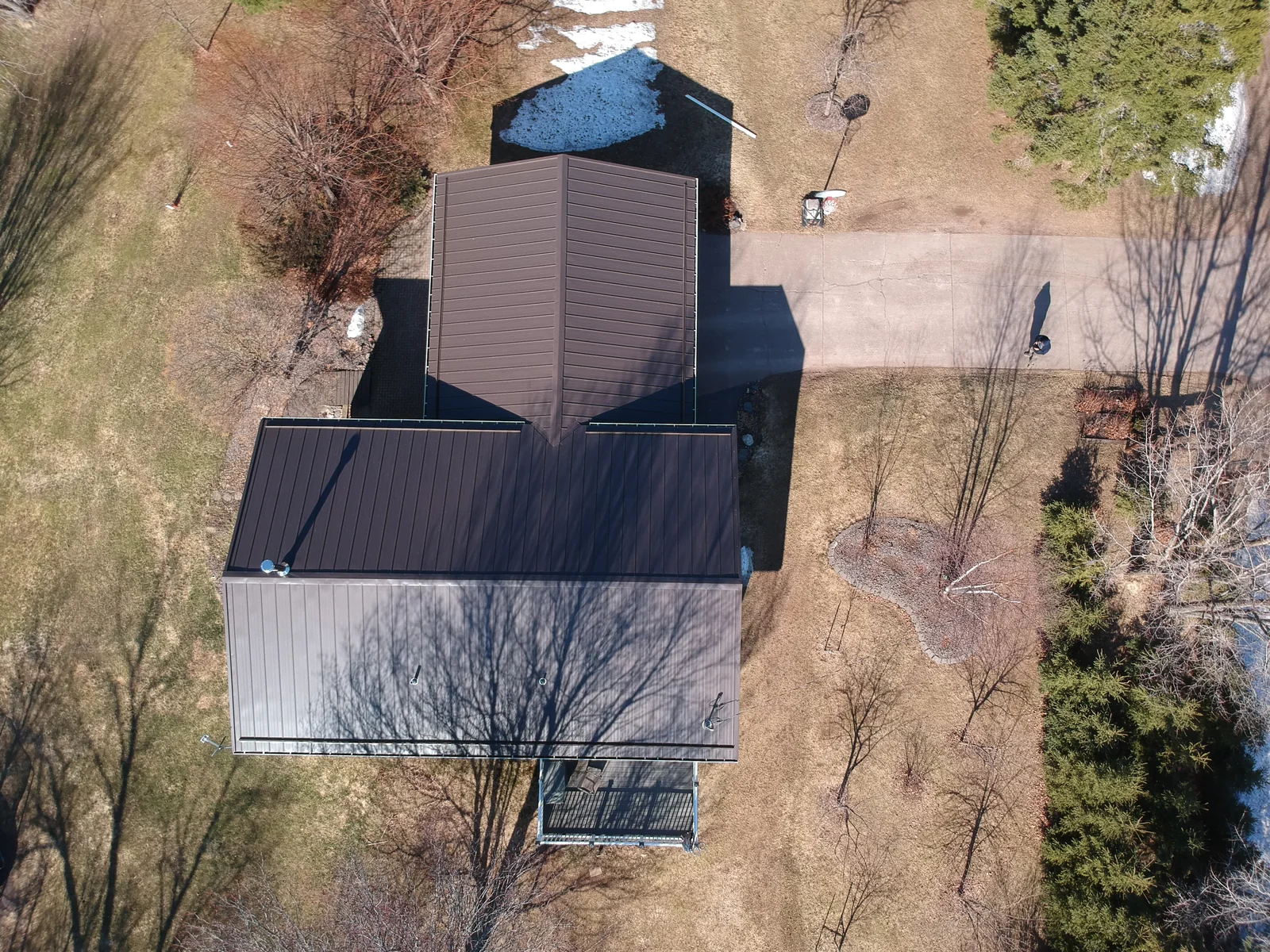 Overhead view of the brown metal roof showing its hip and gable sections and clean ridge lines.
