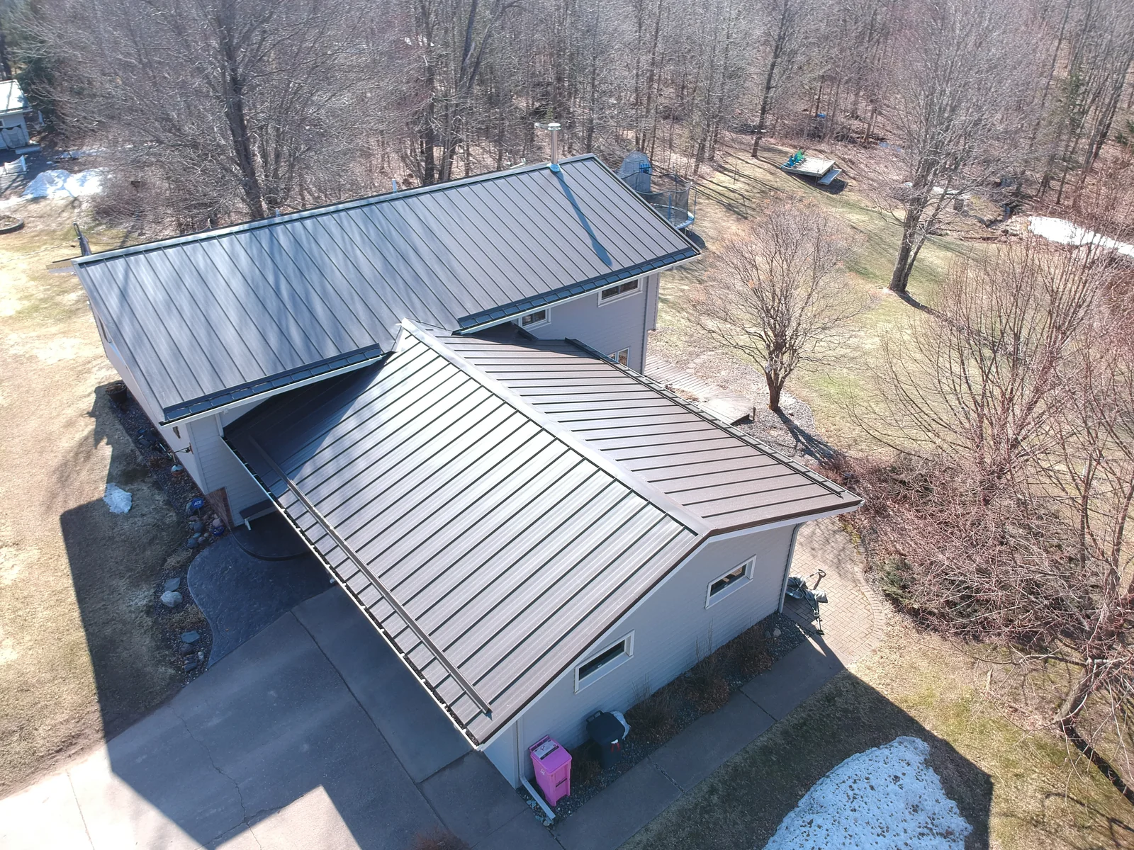 Aerial of the home and garage both topped with the new brown standing seam metal.