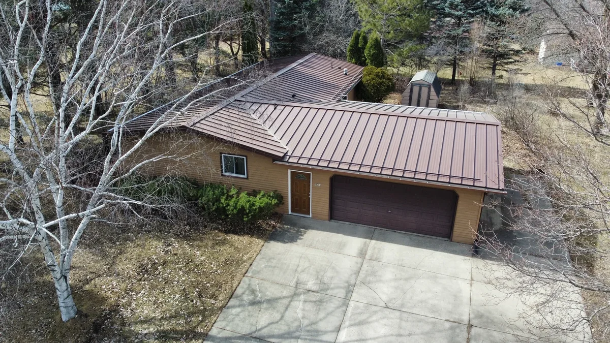 Angled overhead shot of the bronze standing seam panels above the driveway and garage