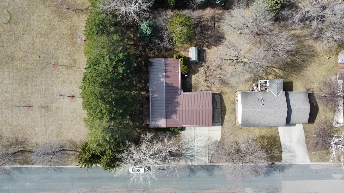 Overhead view of the bronze roof with the garage front and a small backyard shed