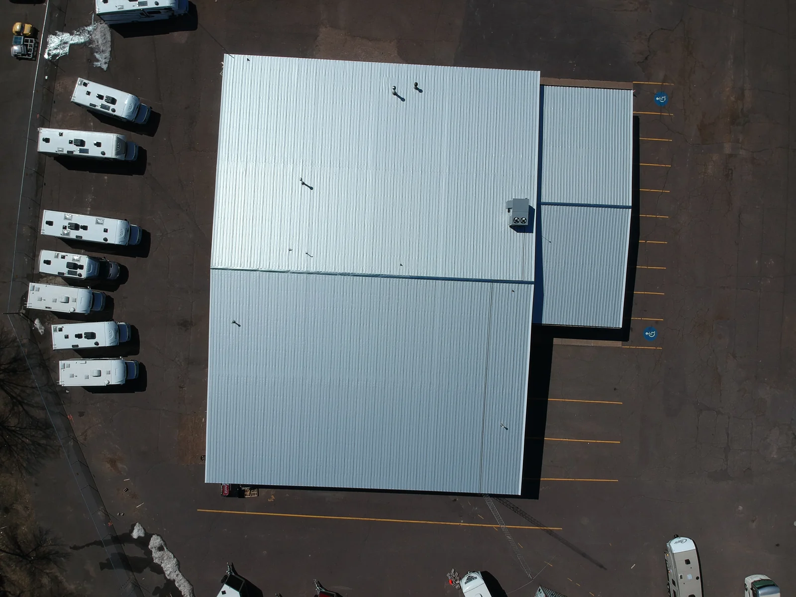 Overhead view of the clean white metal roof panels across the rectangular building