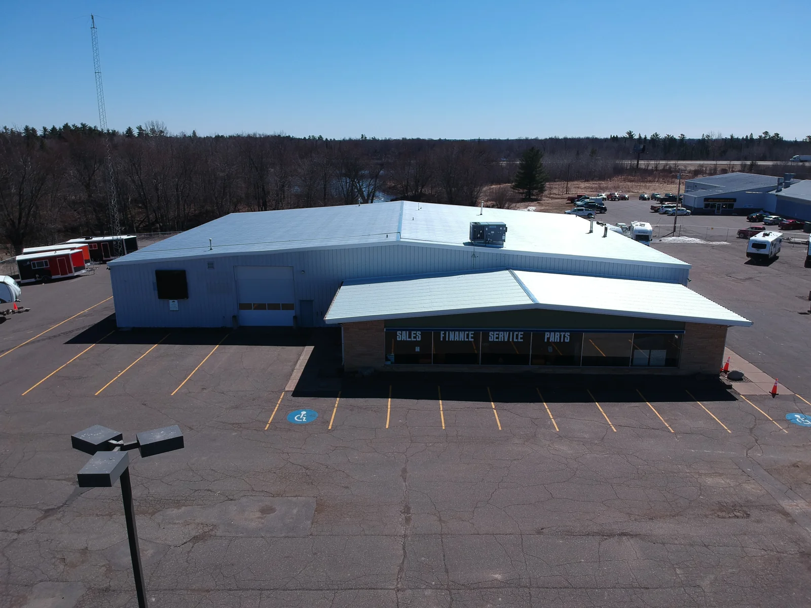 Lower view showing the white-roofed showroom and storefront entrance