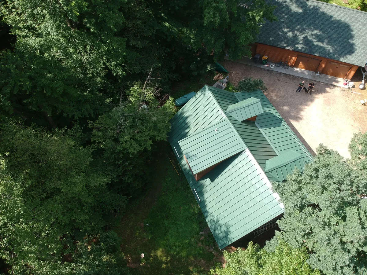 Corner view of the green standing seam panels framed by the surrounding canopy.