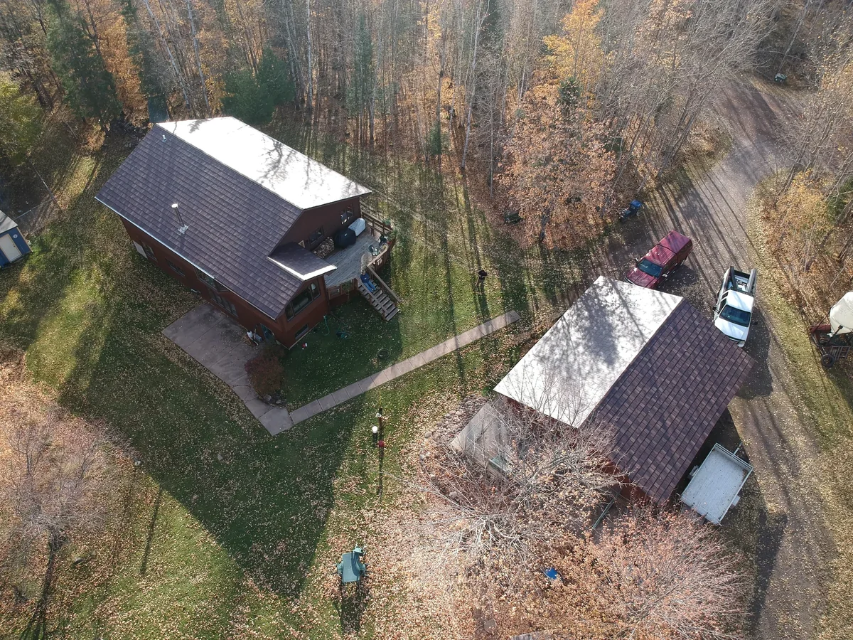 View across the yard toward the home and its detached metal-roofed outbuilding.