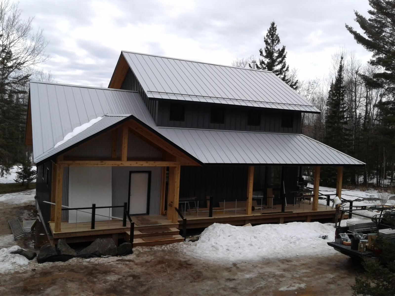 View of the silver metal roof and matching dormer over the board-and-batten facade