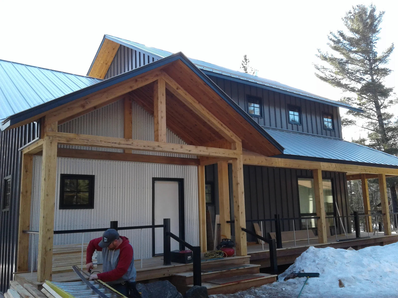 Front angle showing the metal roofline, exposed timber framing and entry porch
