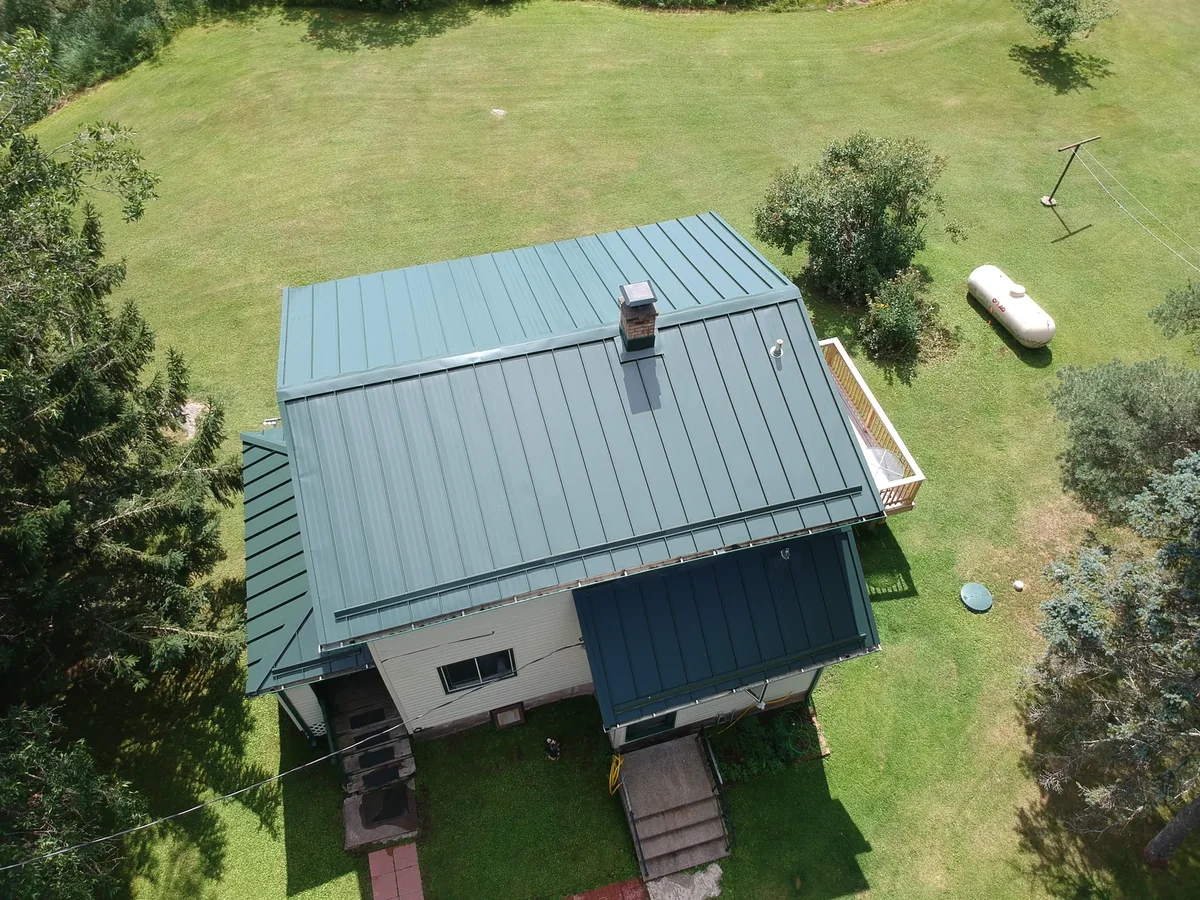 Closer look at the blue standing seam panels and ridge over the home's wings.
