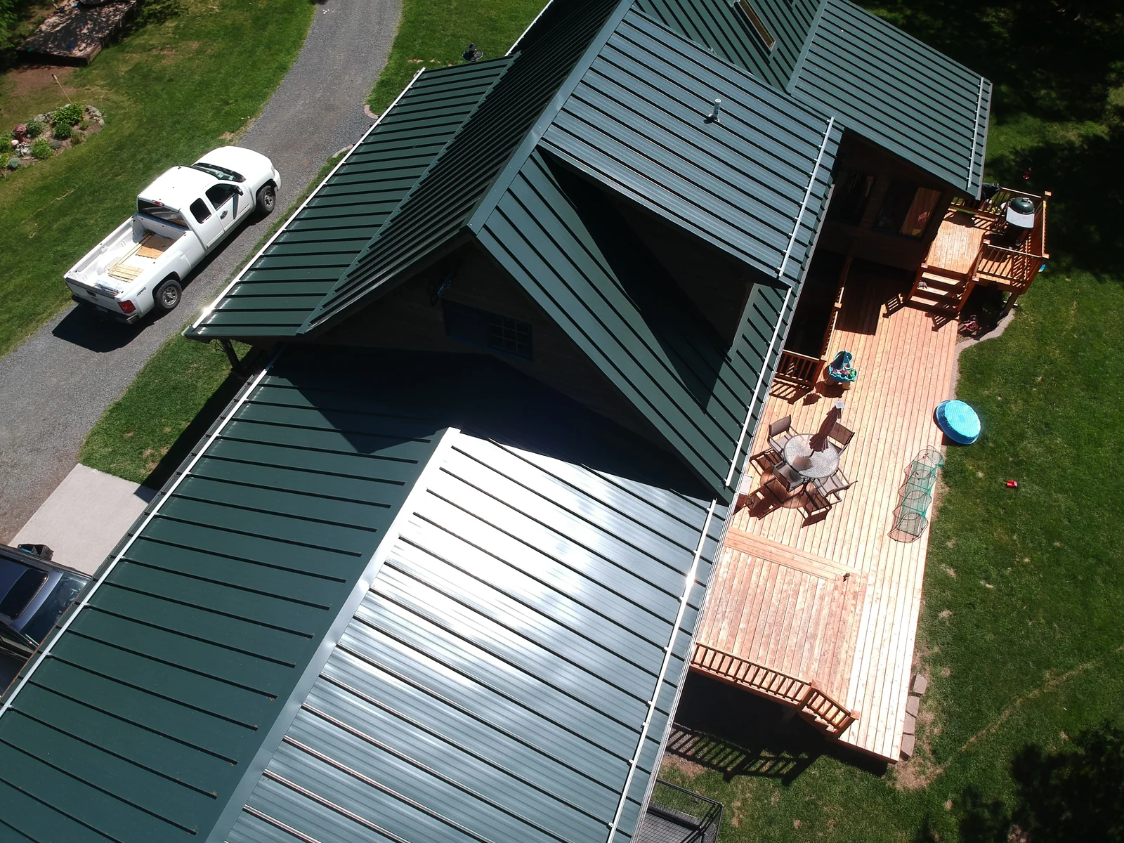 Angled aerial of the green metal roof gables among the surrounding woods