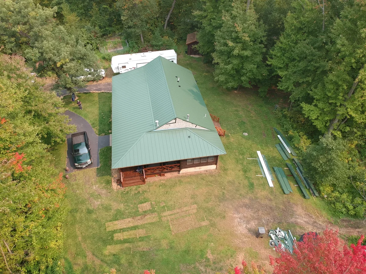 The green metal roof from above surrounded by trees turning red and gold.