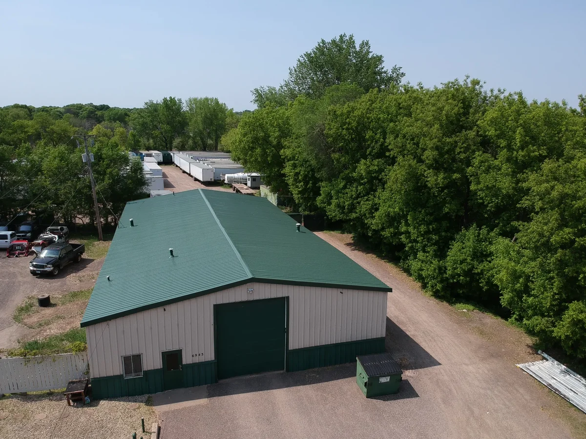 Aerial view of a commercial building in Rochester, MN with a dark green standing seam metal roof