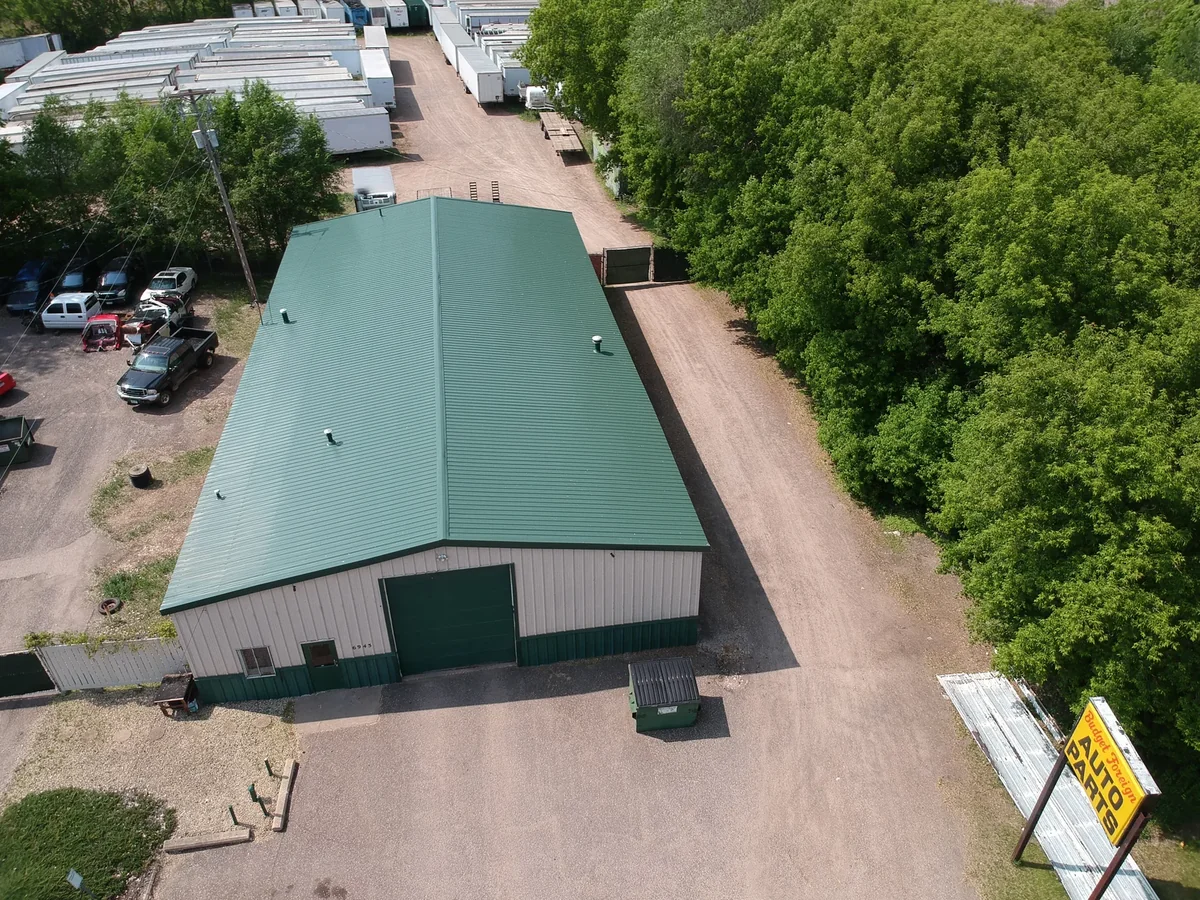 Overhead view of the green standing seam roof framed by surrounding trees