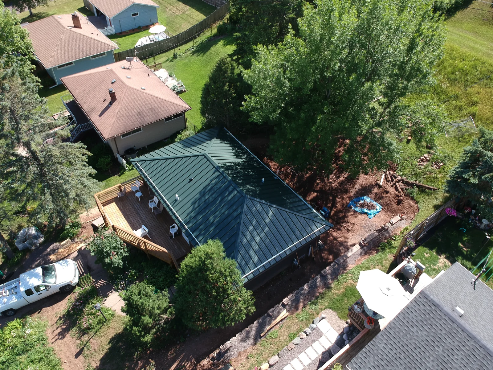 Aerial view of an evergreen standing seam metal roof on a home among neighboring houses in St. Cloud, MN