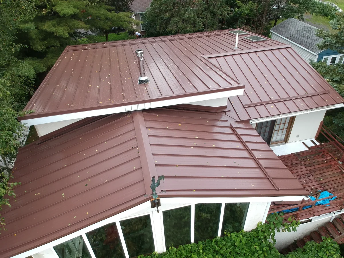 Aerial view of a lakeside home with a warm brown standing seam metal roof in Superior, WI.