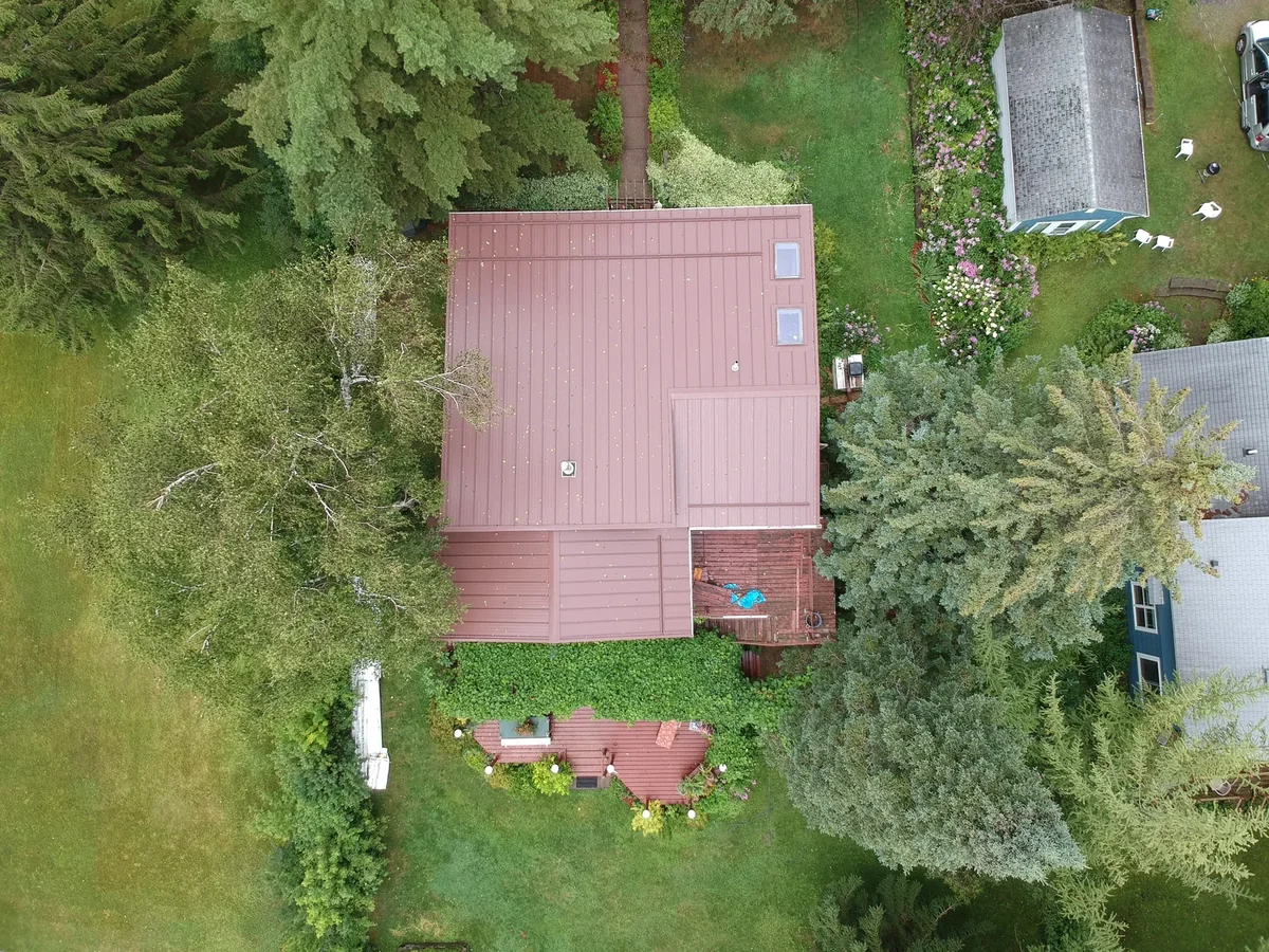 Top-down view of the brown metal roof and its multiple gable sections.