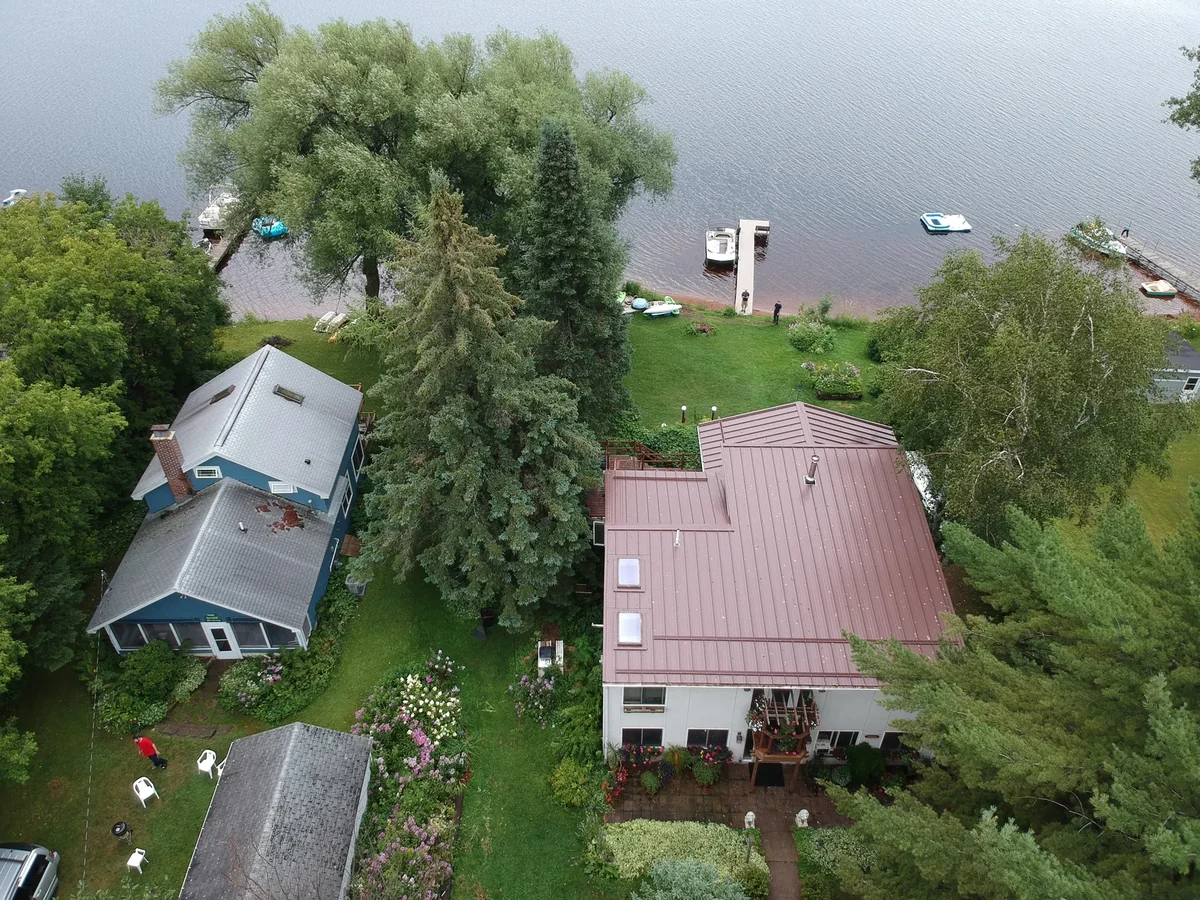 Elevated view of the house and yard sloping down toward the lakeshore.