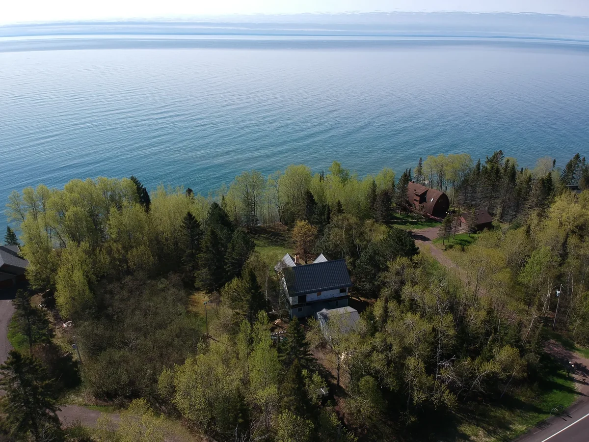 Aerial view of a lakeside home near Two Harbors, MN with Lake Superior stretching beyond the trees