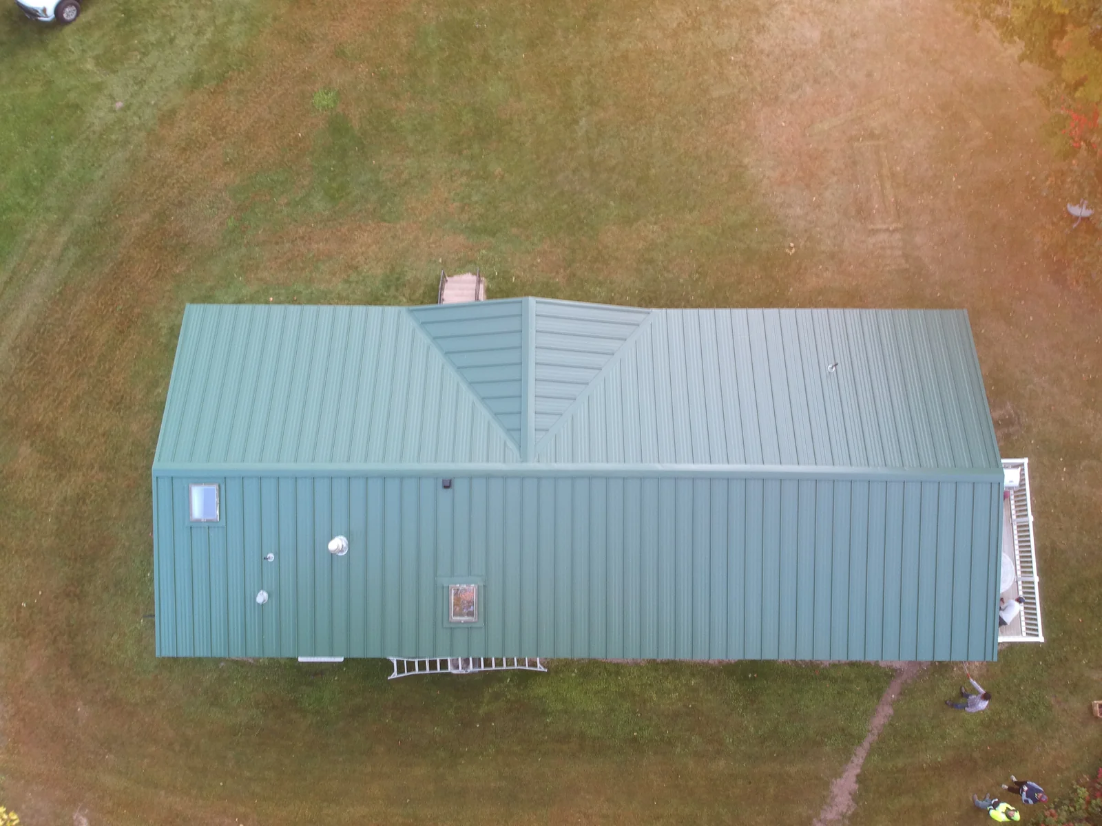 Top-down view of the dark green metal roof spanning the full length of the home.