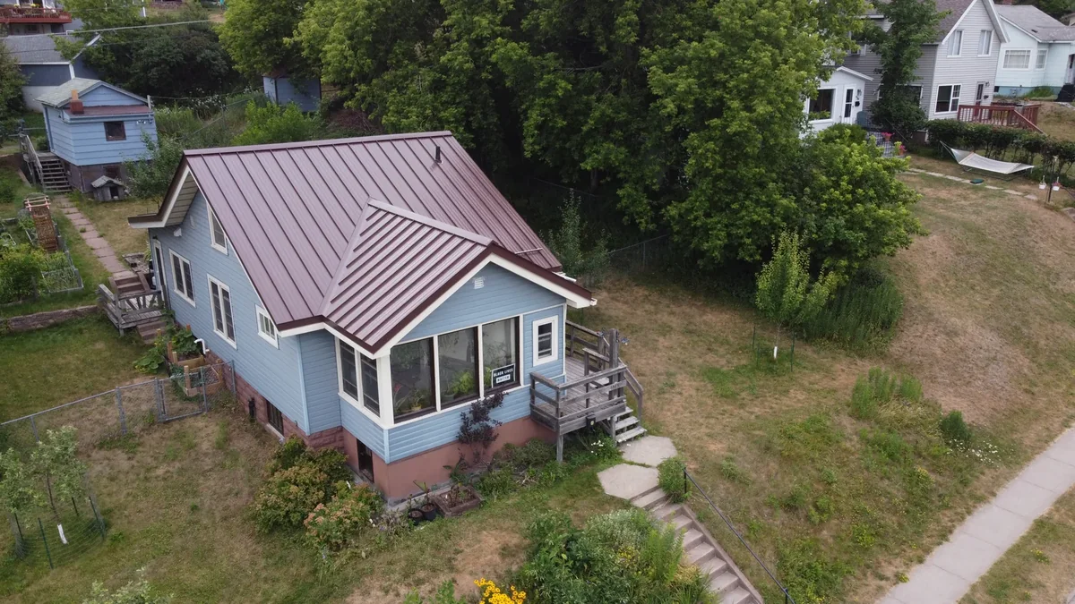 Overhead detail of the dusky red standing seam panels and the walkway below